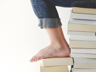 child's feet on pile of books