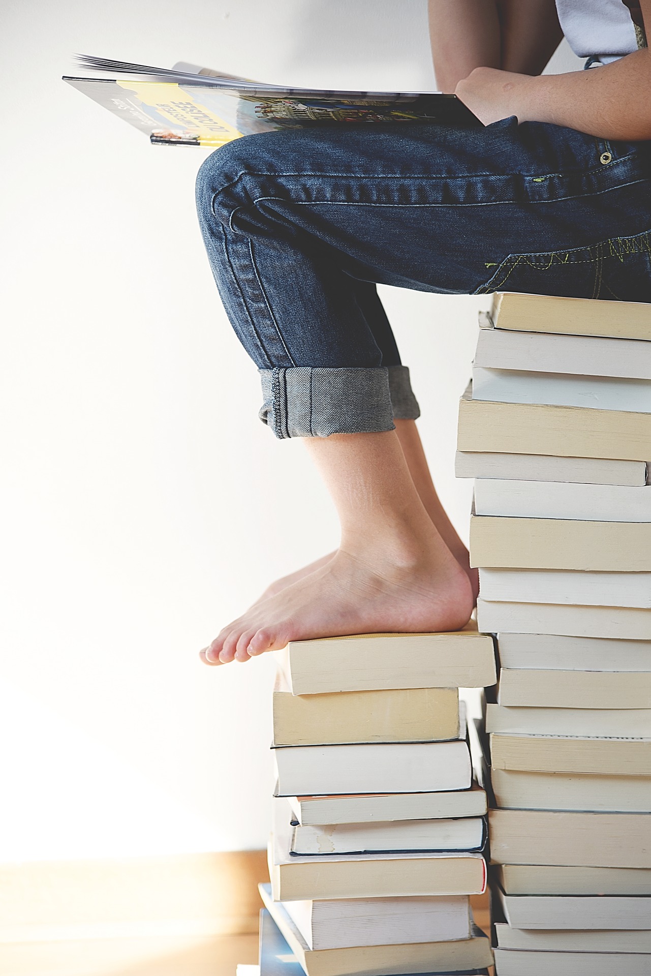 child's feet on pile of books