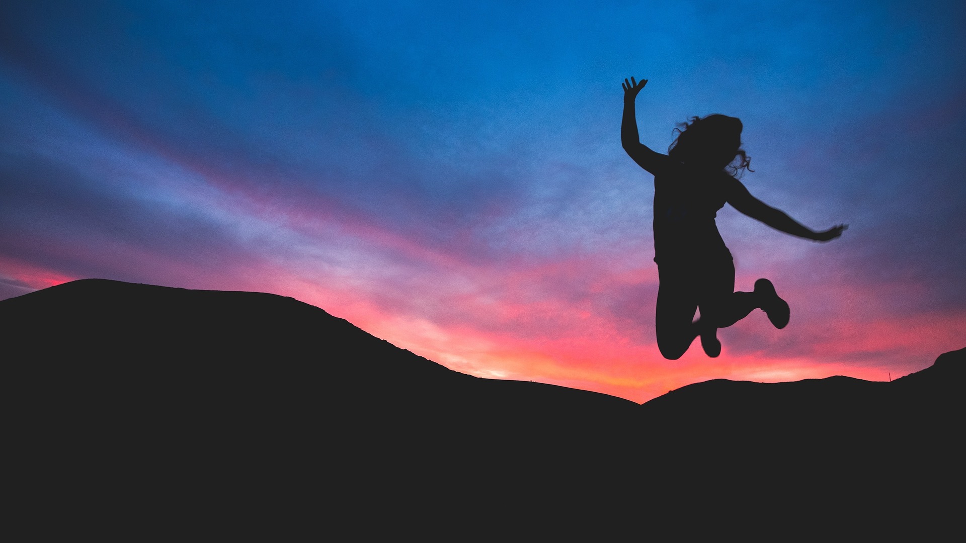 girl jumping at sunset