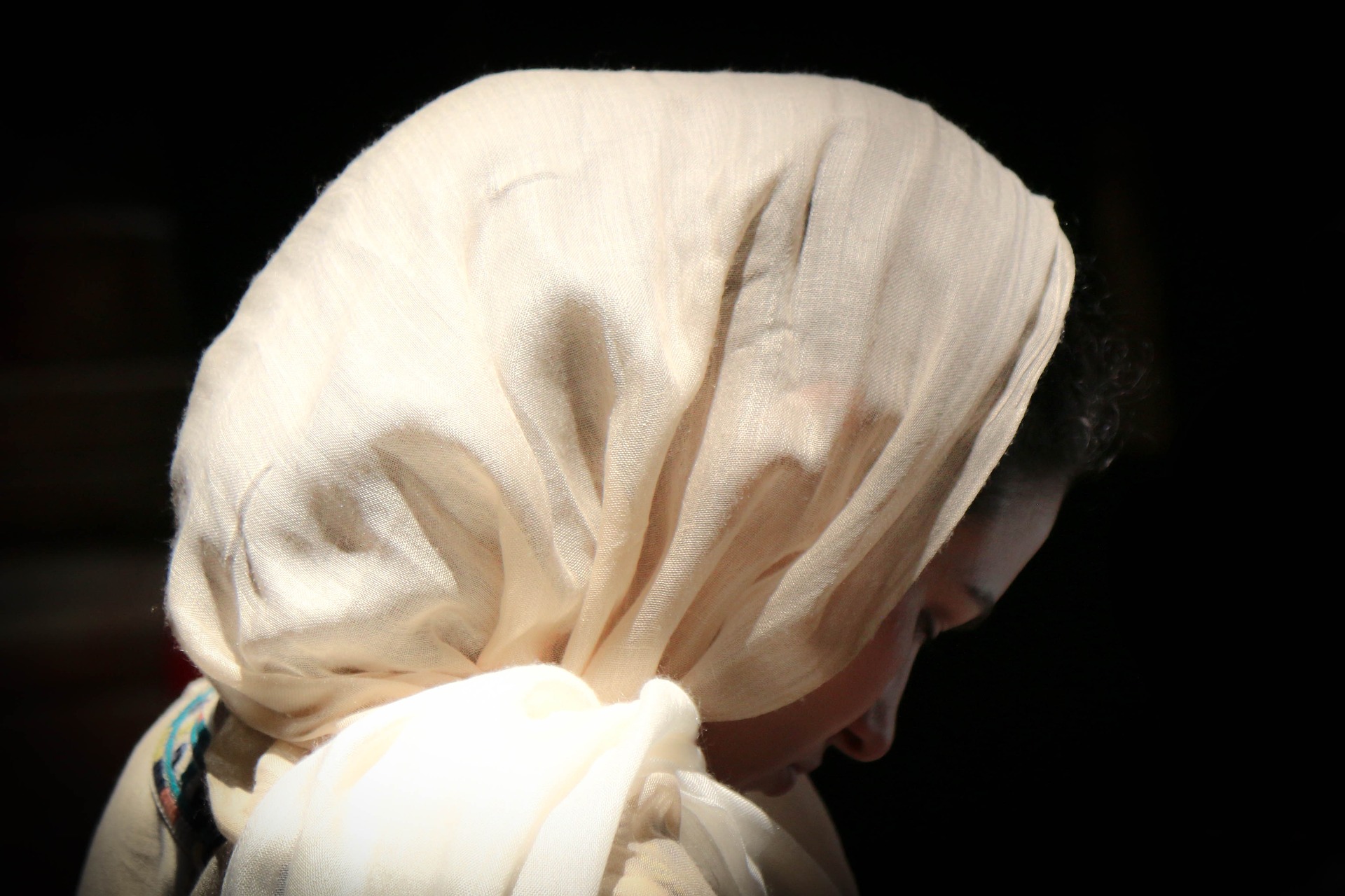 Woman with head covering praying
