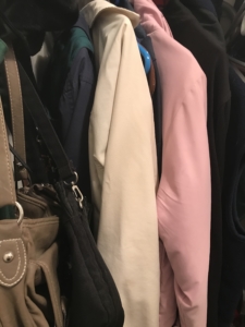 closet with clothes and purses