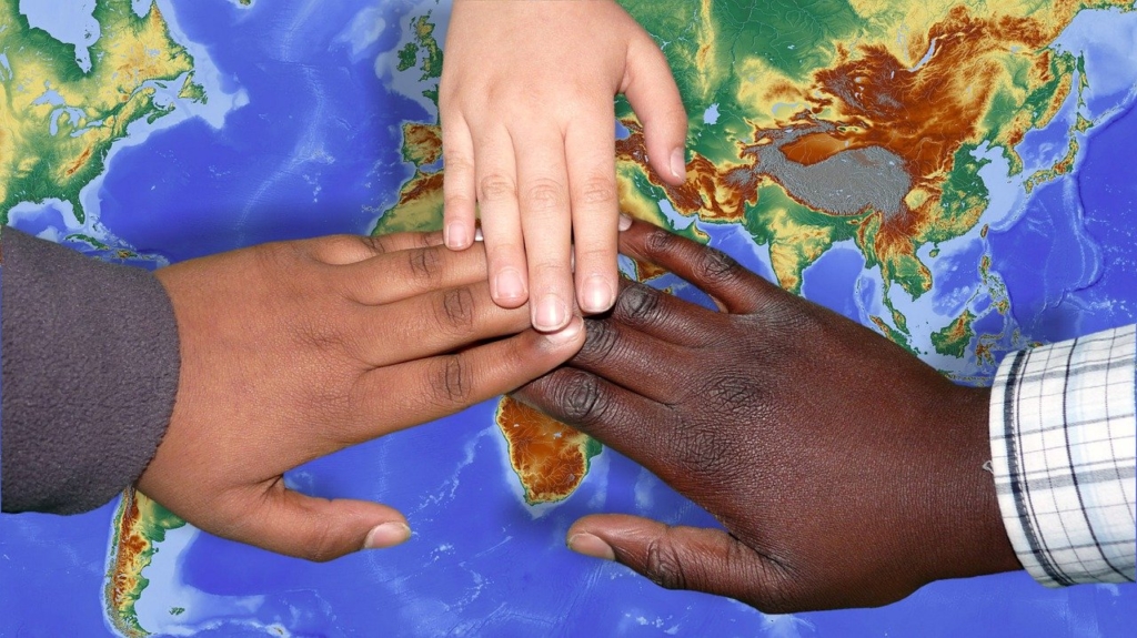 Children's hands over a world map